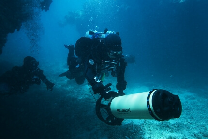 SUEXの大型の水中スクーターを始動するテクニカルダイバー